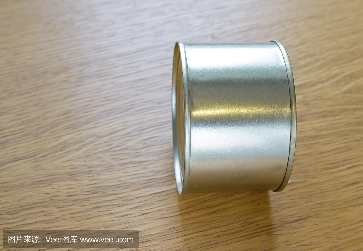 金属罐放在一张木桌的末端