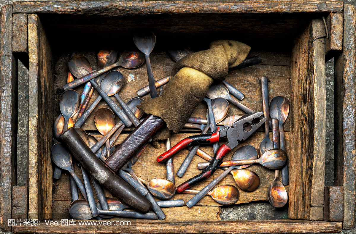 青铜餐具厂内手工制作的勺子、叉子、铁锤、钳子等青铜餐具,形象为工业背景